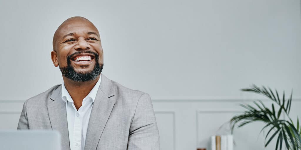 Man smiling confidently, highlighting the impact of dental care and oral health on a professional appearance