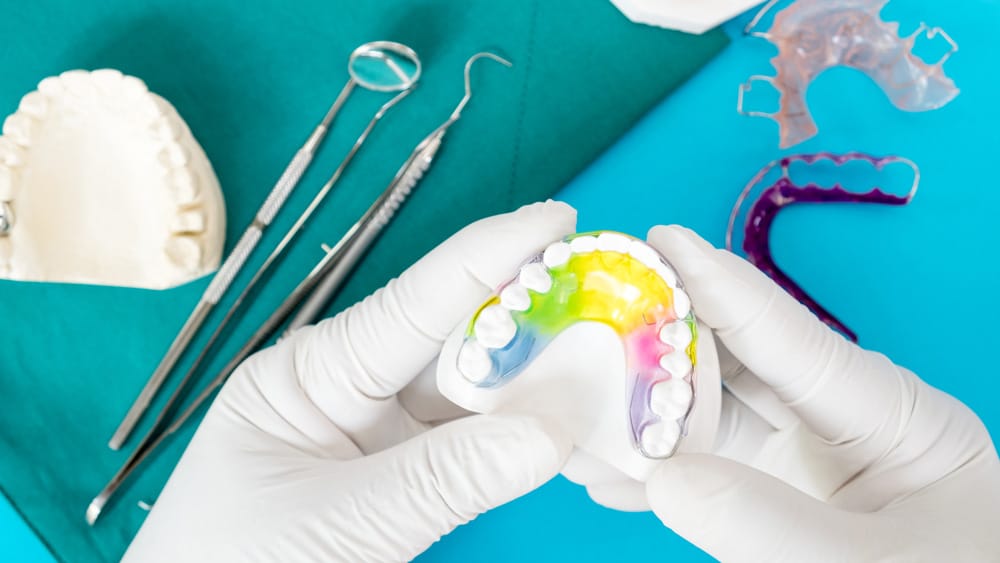 Dentist's hands carefully holding a custom dental sleep appliance used for treating sleep apnea in minors, during a consultation in Stillwater, MN