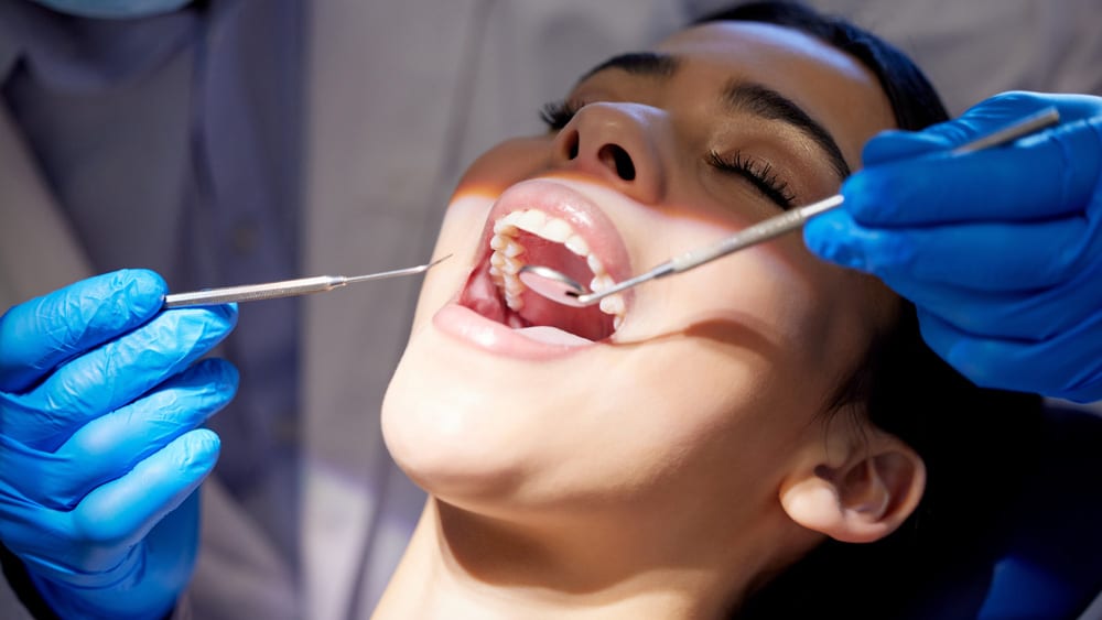 Woman receiving laser bacterial reduction treatment from her dentist in Stillwater, MN