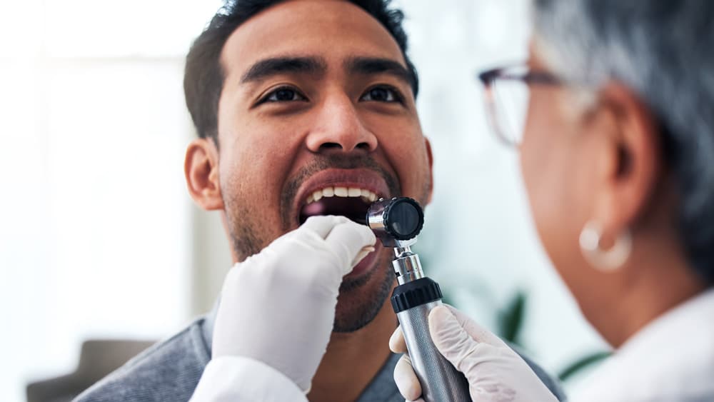 Man undergoing oral cancer screening by his dentist in Stillwater, MN